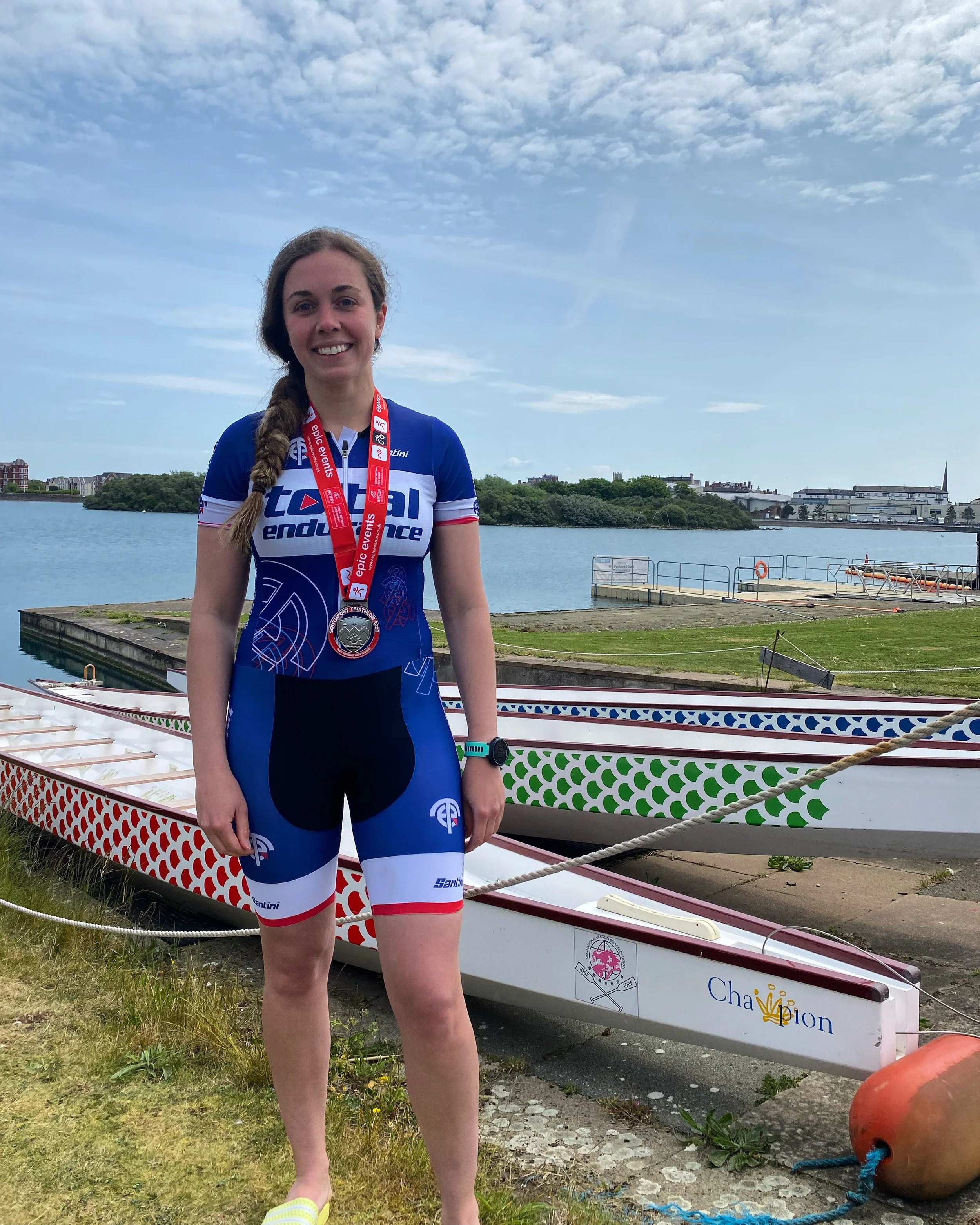 Lindsey Young, Total Endurance athlete, with her race medal after finishing a triathlon