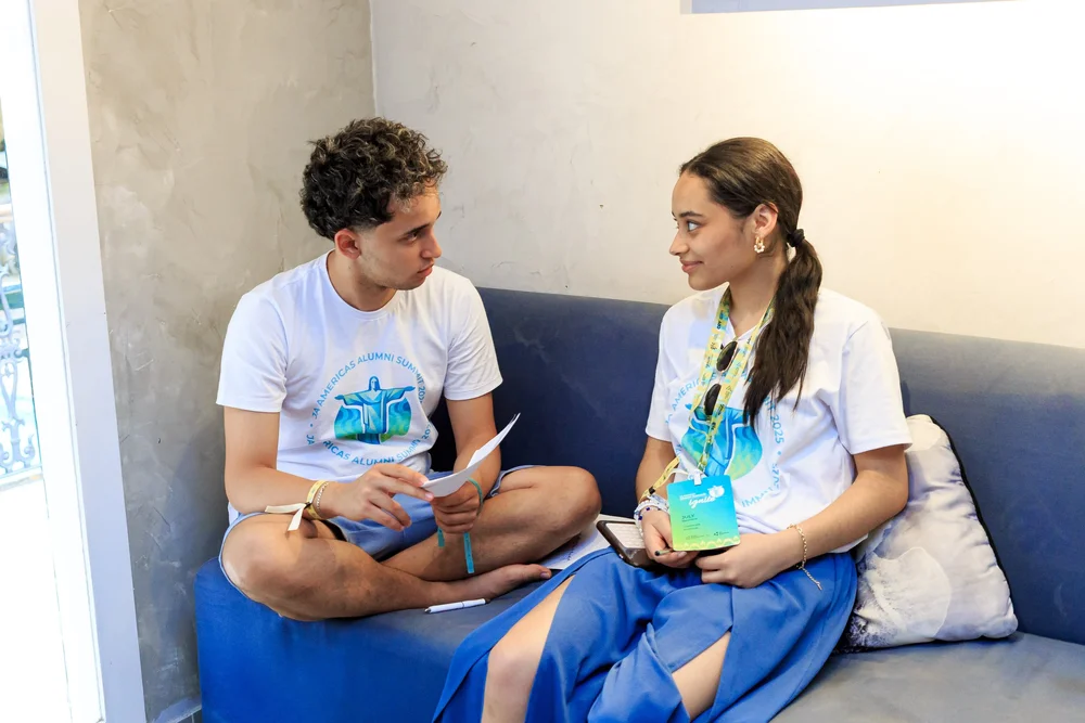 Two alumni talking on a couch during a break