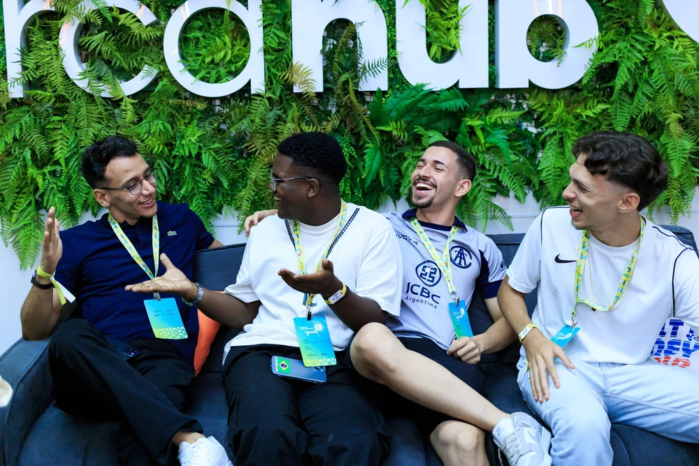 Alumni laughing together on a sofa
