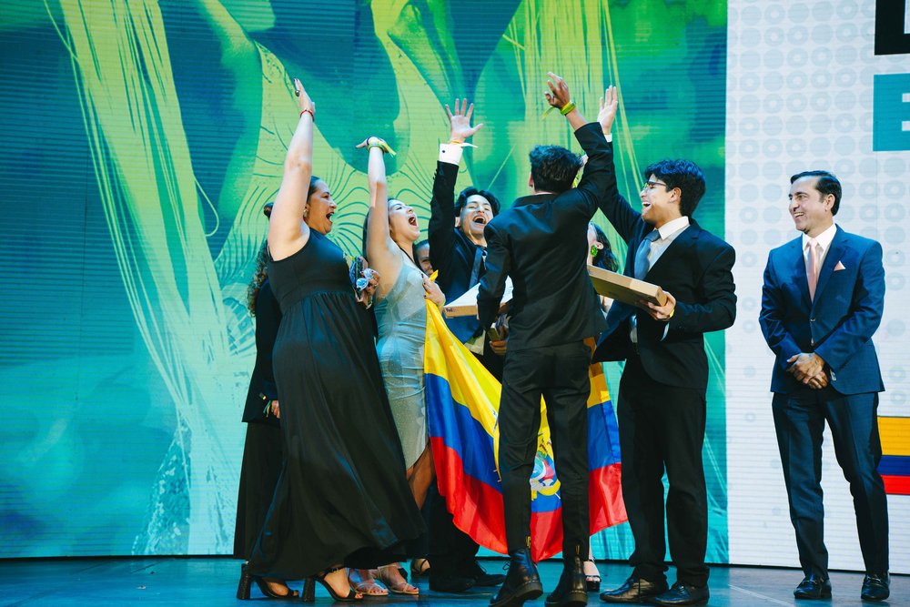 Winners celebrating on stage with the Ecuadorian flag