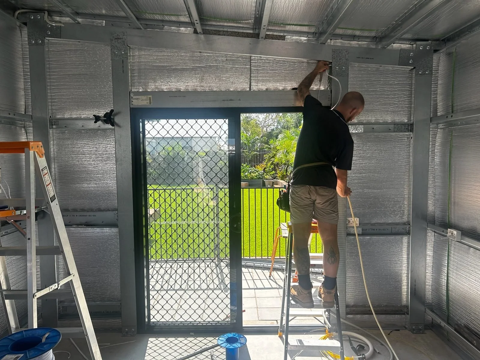 Electrician running cable in a steel-framed build