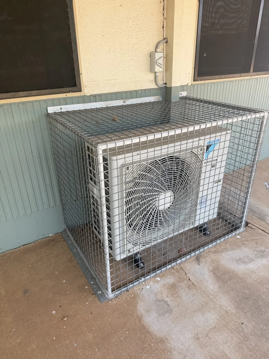 Caged Daikin condenser protecting a remote install