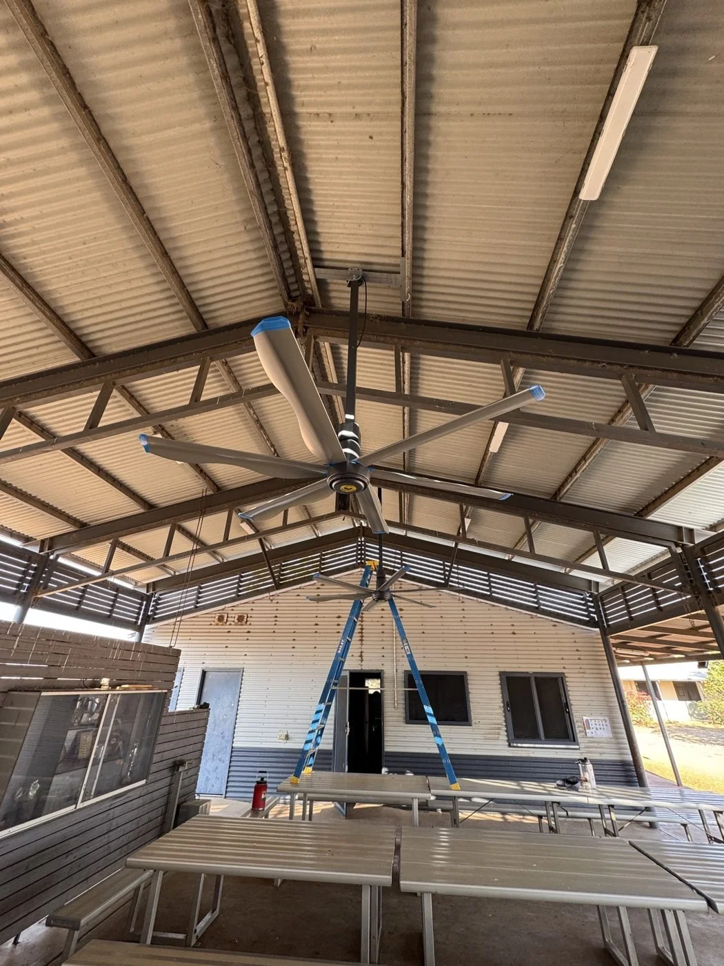 Large industrial ceiling fan installed in a community shelter