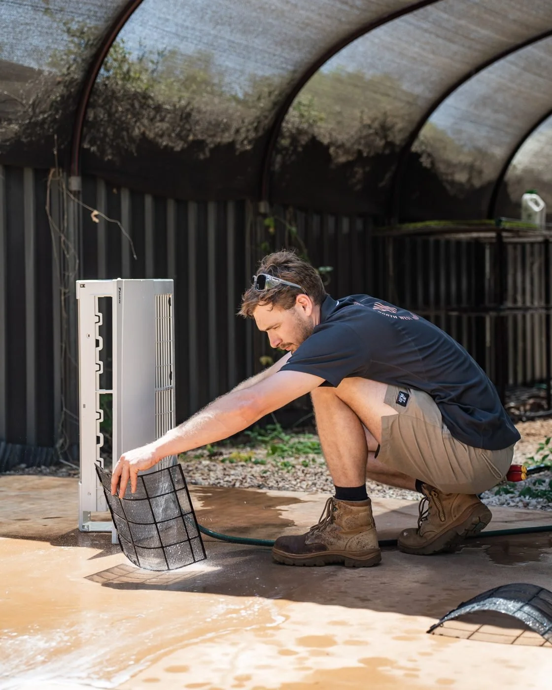 Washing air conditioner filters during a scheduled service