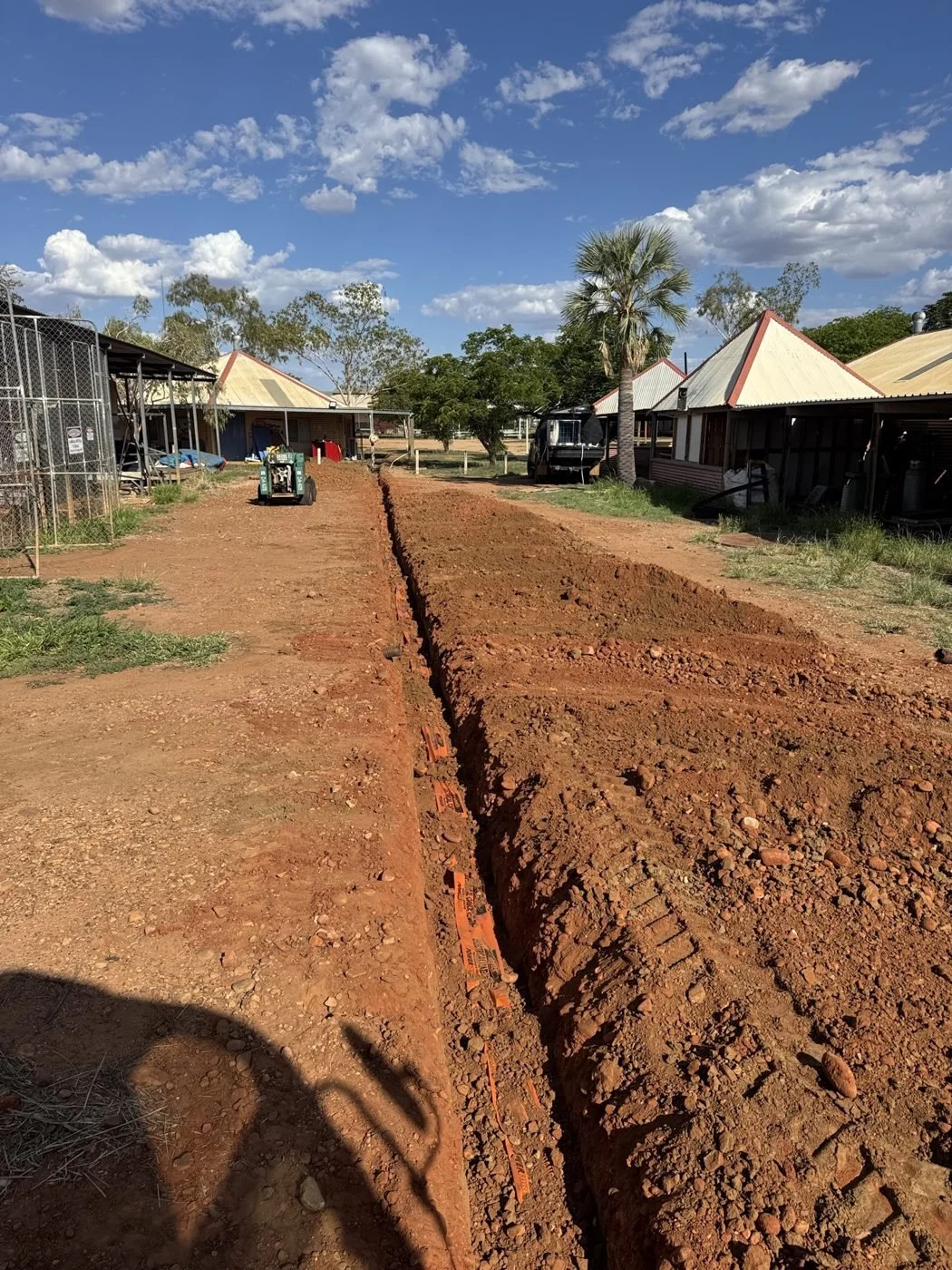 Trenching underground electrical conduit on a remote community site