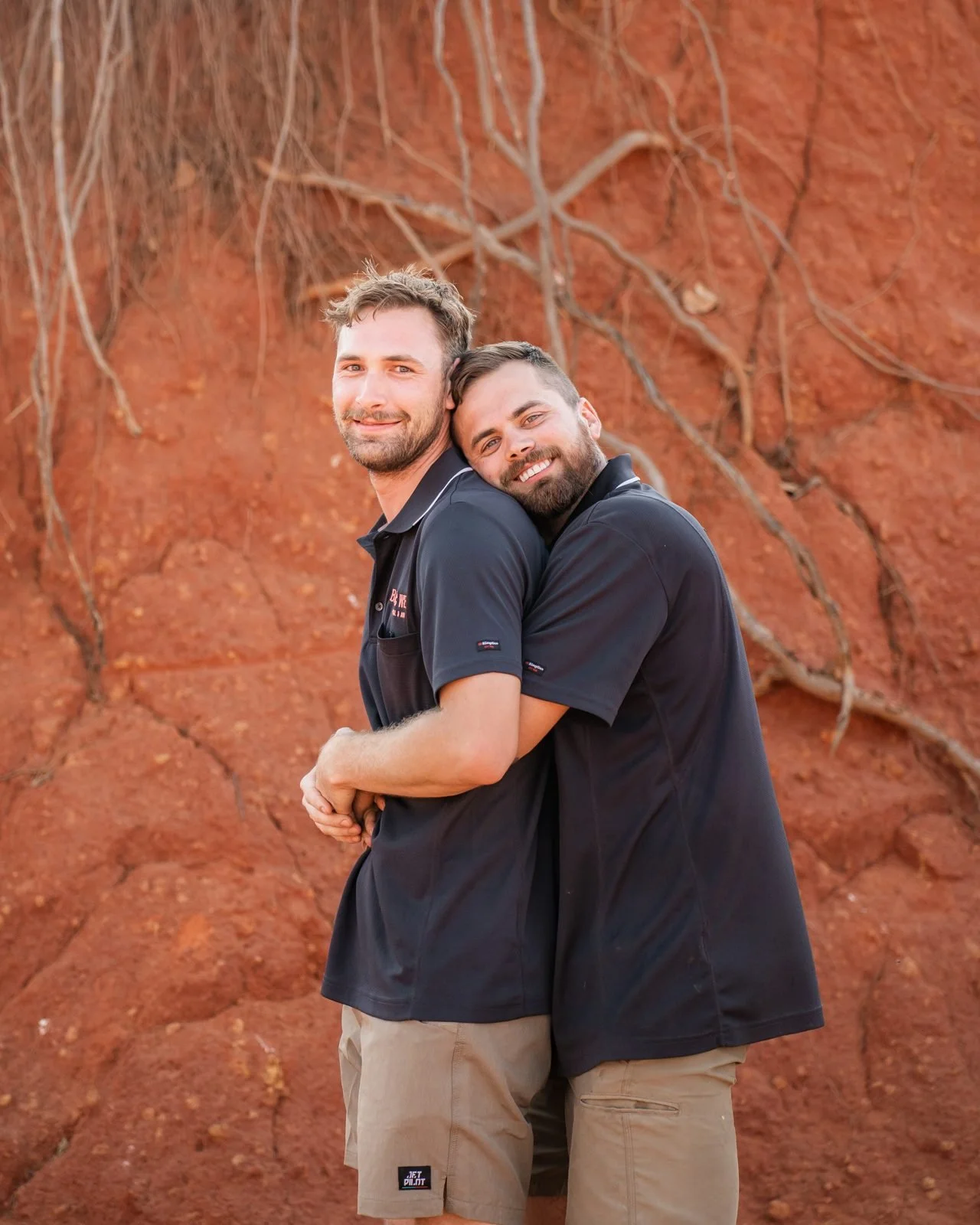Two Bazlec West team members in front of a pindan cliff