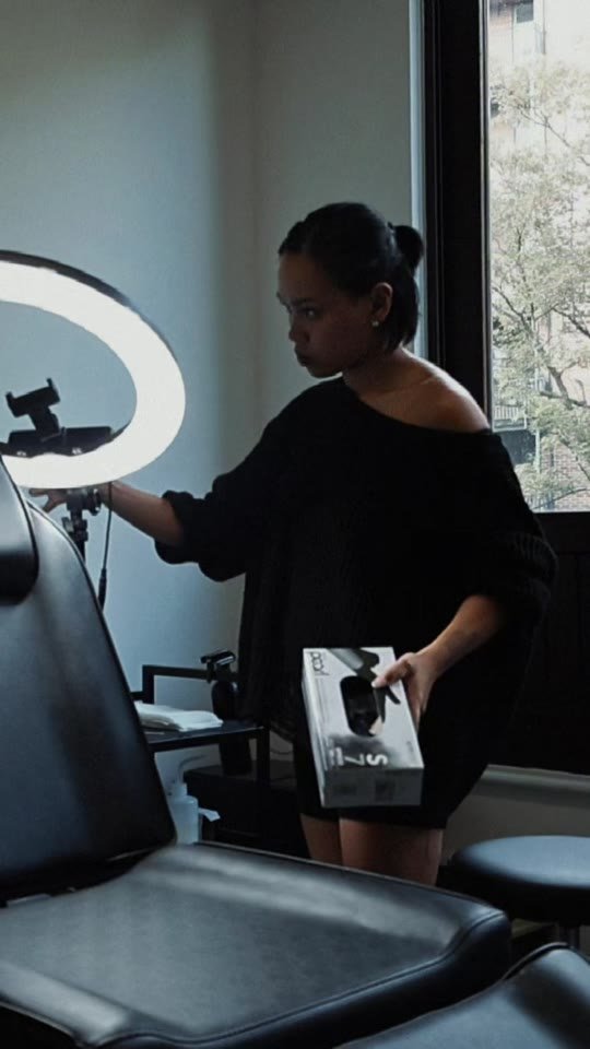 Kimberley setting up a tattoo chair by a ring light