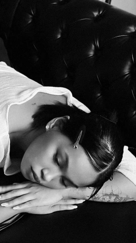 Black and white shot of Kimberley resting on a leather sofa