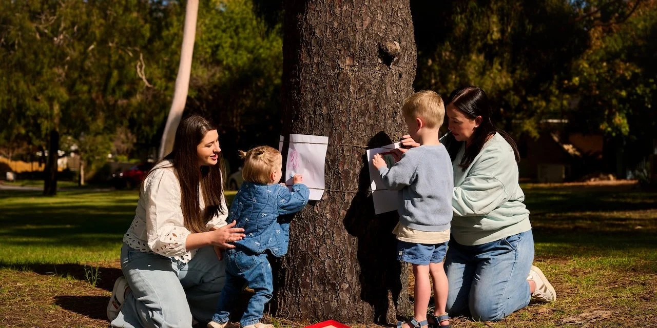 Children drawing on the side of a tree