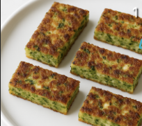 Broccoli and fetta fritters stacked on a plate