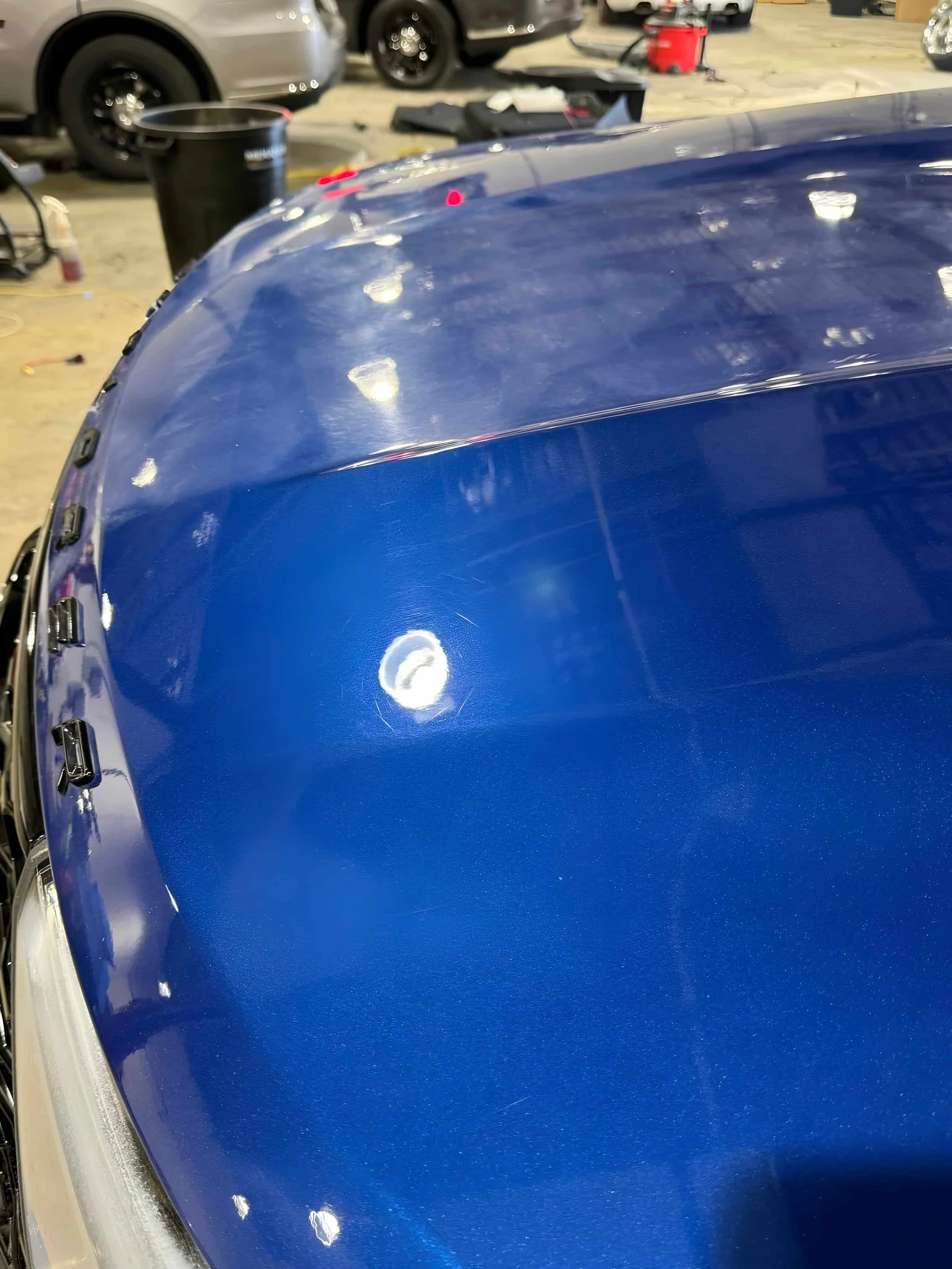 Before and after 2-step paint correction removing swirl marks from black car paint in Miami