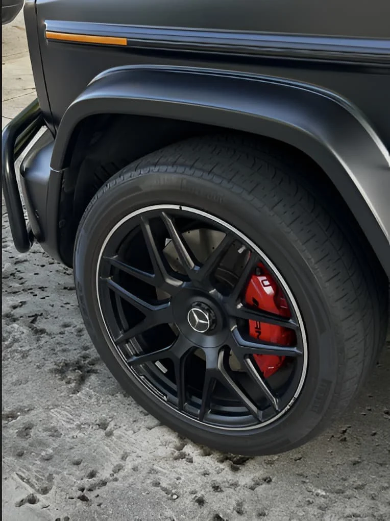 Clean AMG wheel with red caliper on matte black G63, detailed by Ale's Mobile Detailing