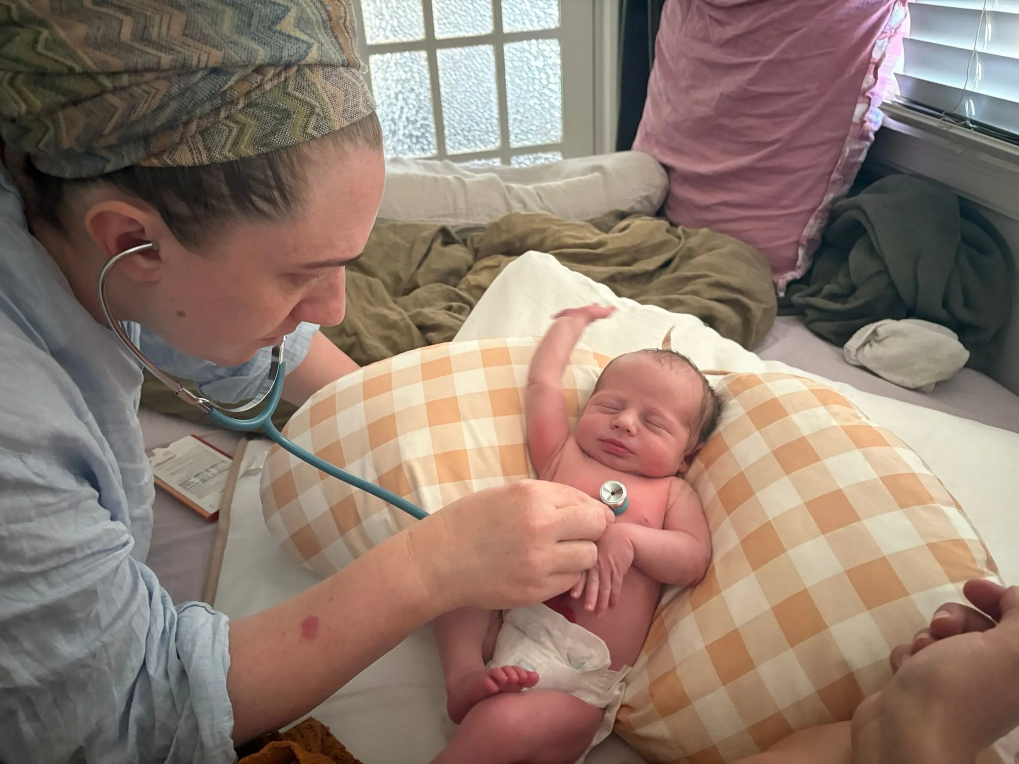 Jennifer Hazi checking a newborn baby at a home postnatal visit