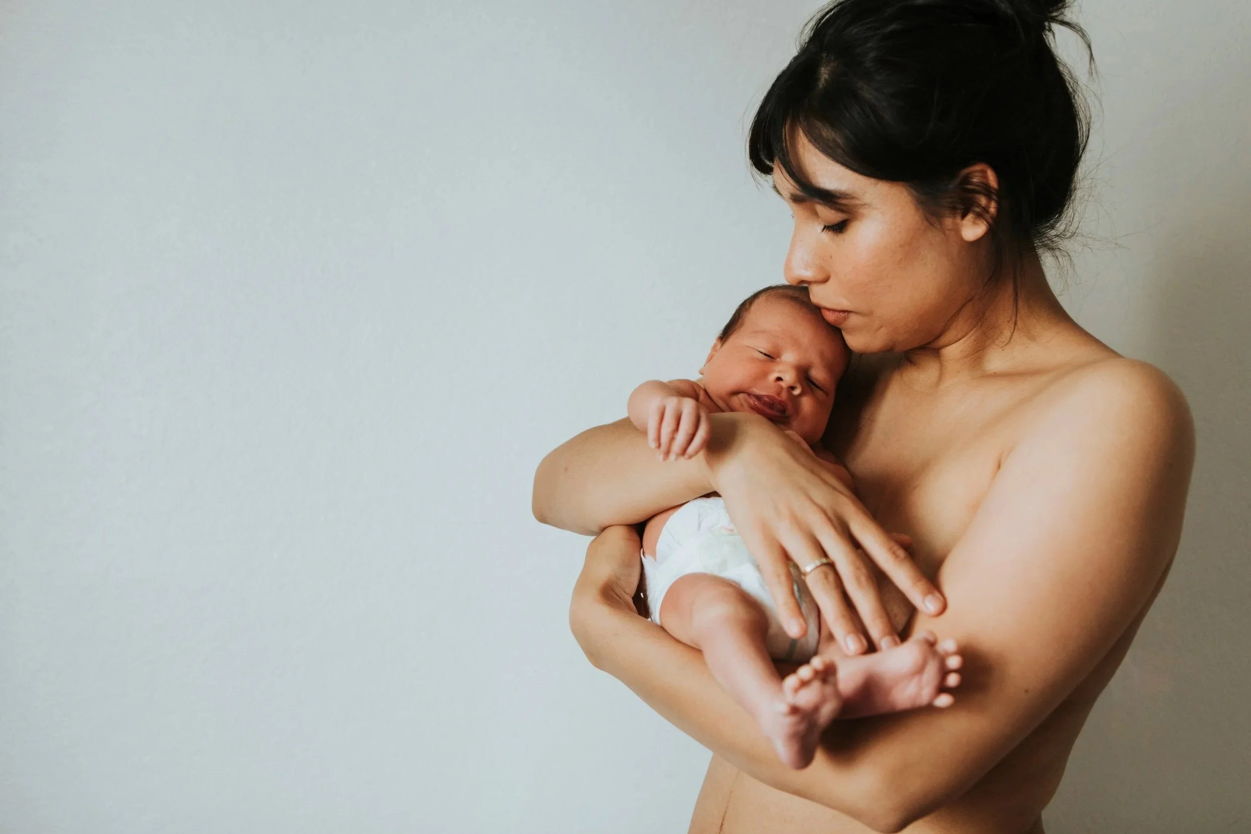 A mother holding her newborn baby skin to skin