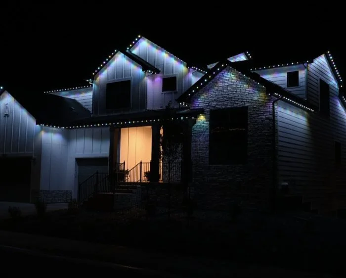 Custom two-story home with colorful roofline lighting on every roofline
