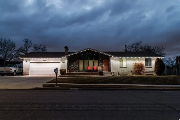 Single-story ranch home with warm white permanent roofline lighting