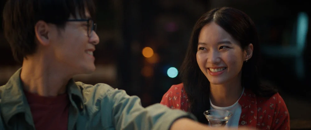 Minh Hiếu and Mộng Hoài share a smile under warm city lights