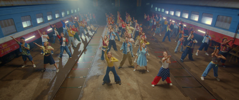 Dancers fill the aisle of a train carriage