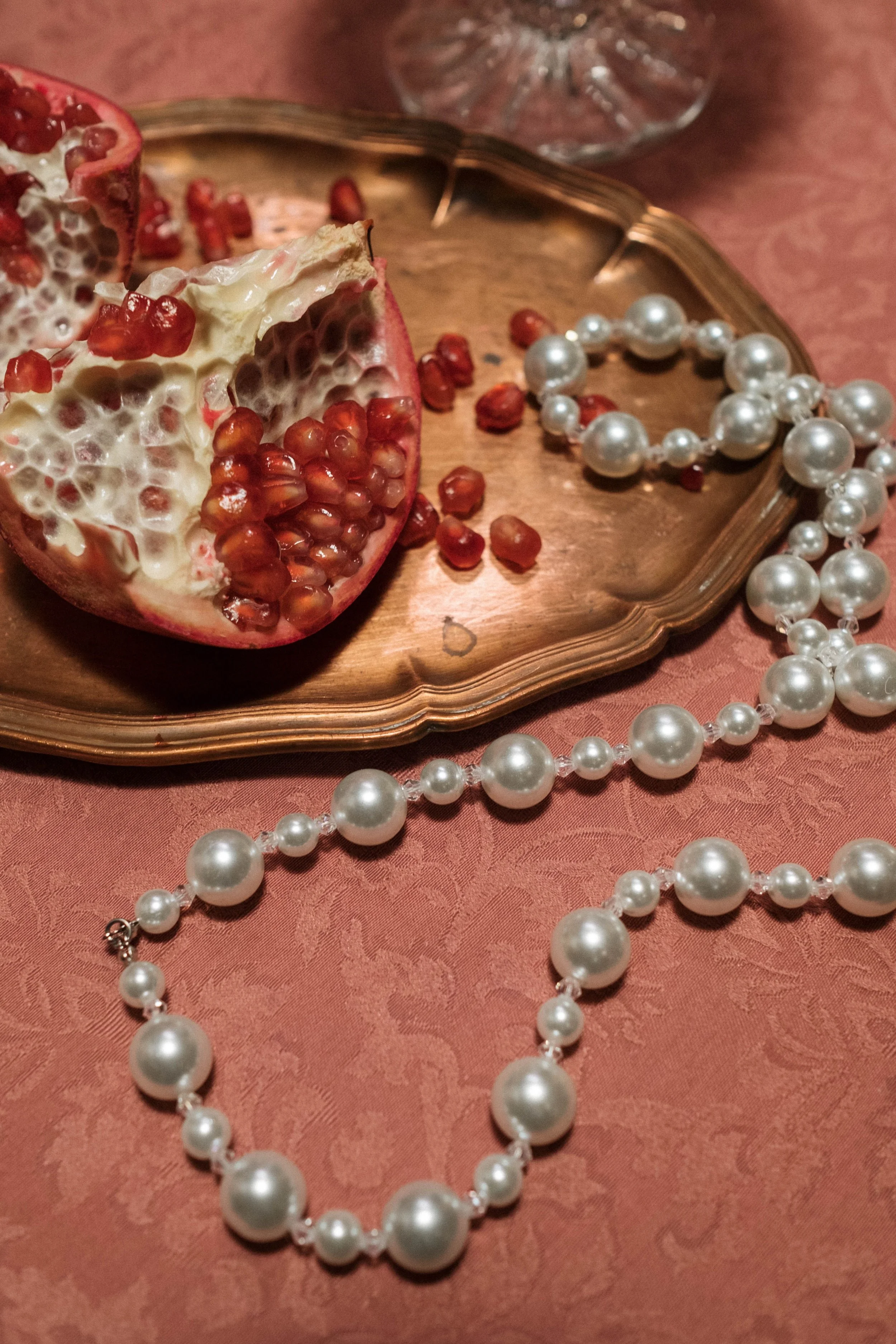 Pomegranate seeds, pearls and oysters on a richly laid table