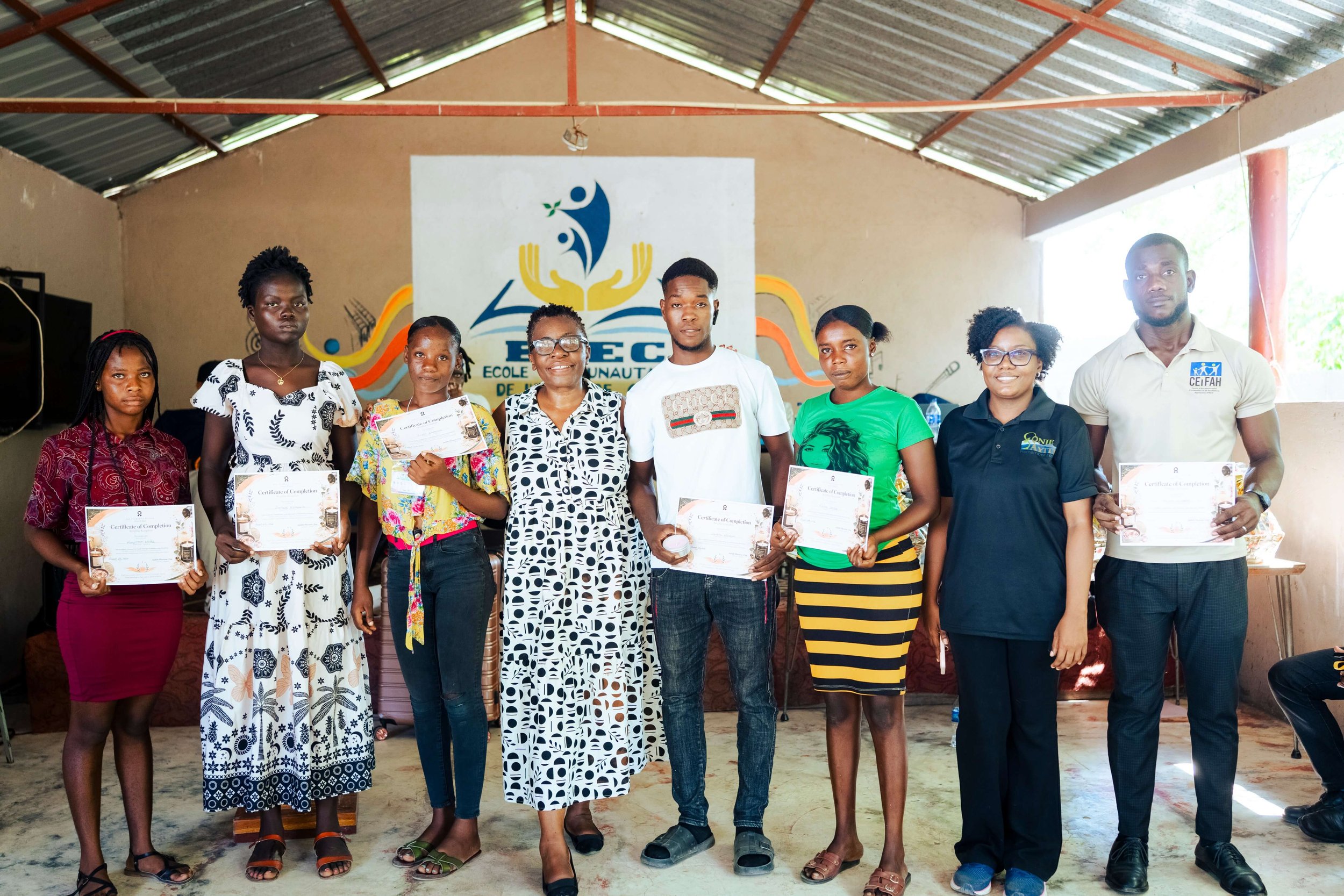 Candle-making participants and community facilitators in Haiti gather with their completed candles and certificates following Beautélanin's August 2026 virtual workshop in partnership with Marie's Kitchen of Love.