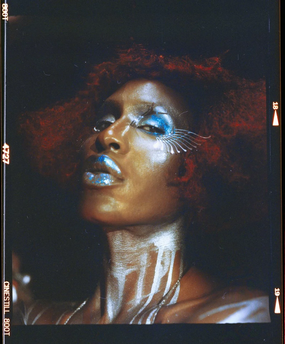 Performer portrait: Shea Couleé in close-up with blue eye make-up and red hair.