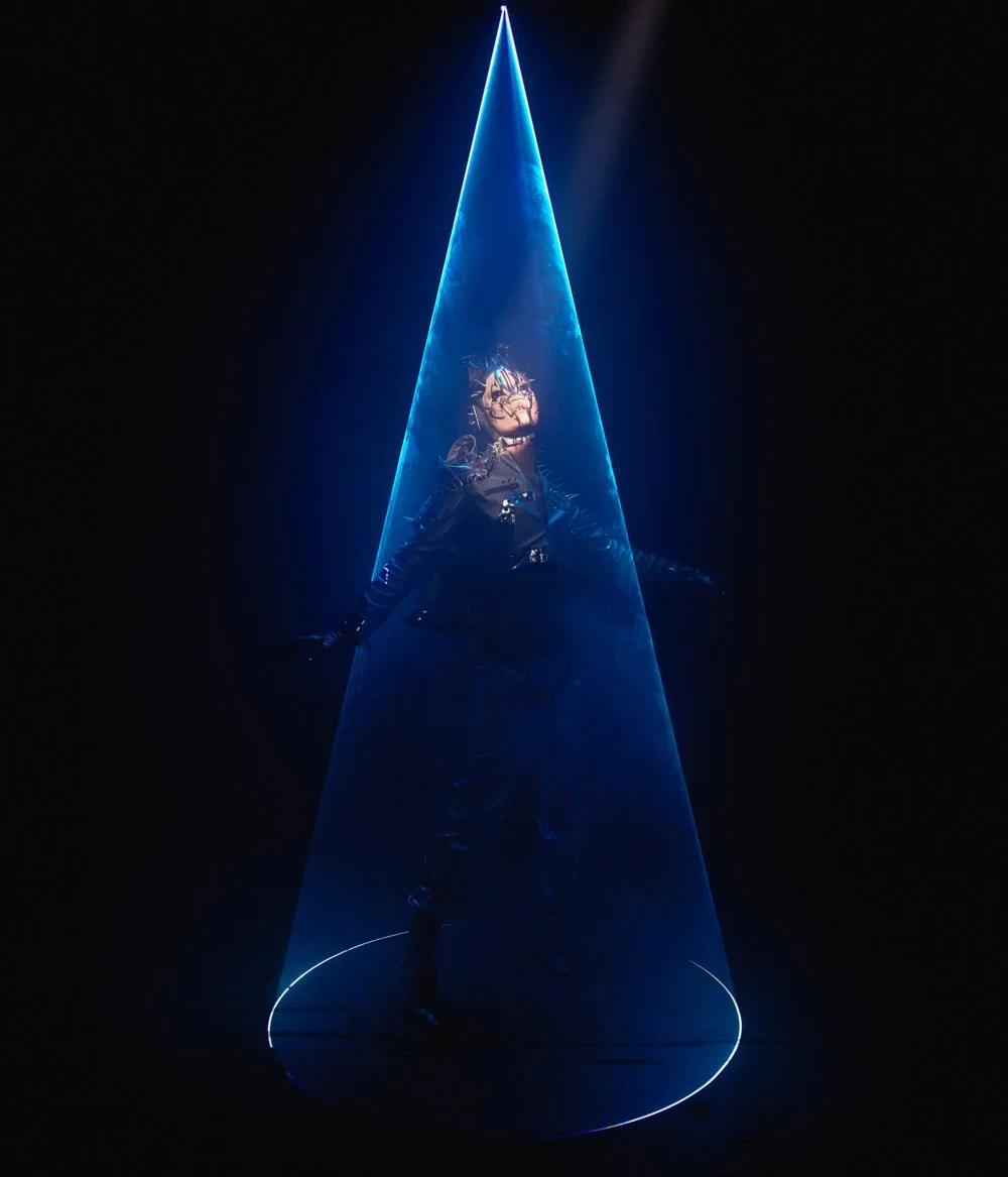 Performer portrait: Hungry lit by a single blue beam in a dark studio.