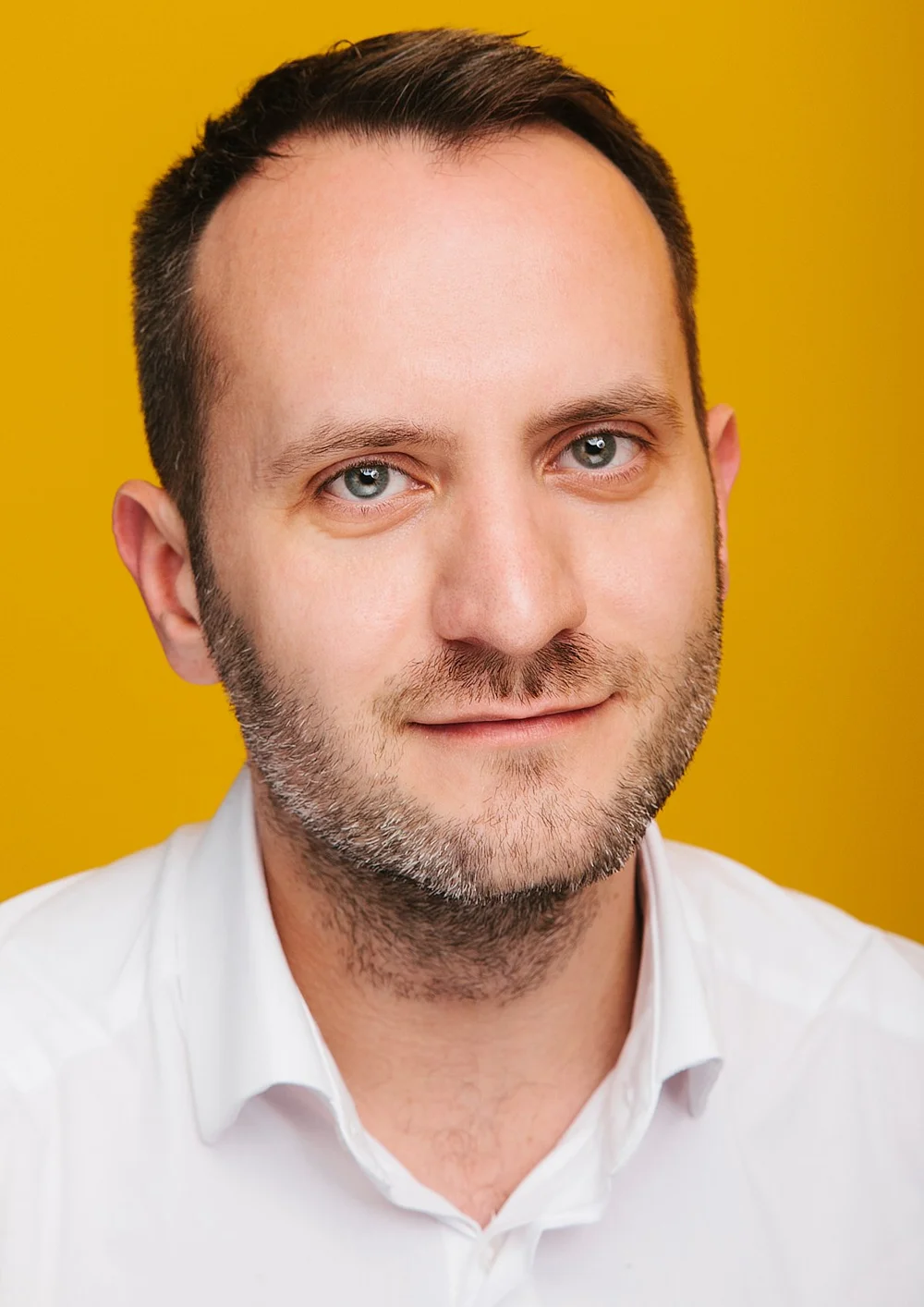 Corporate headshot: close-up on a clean studio backdrop.