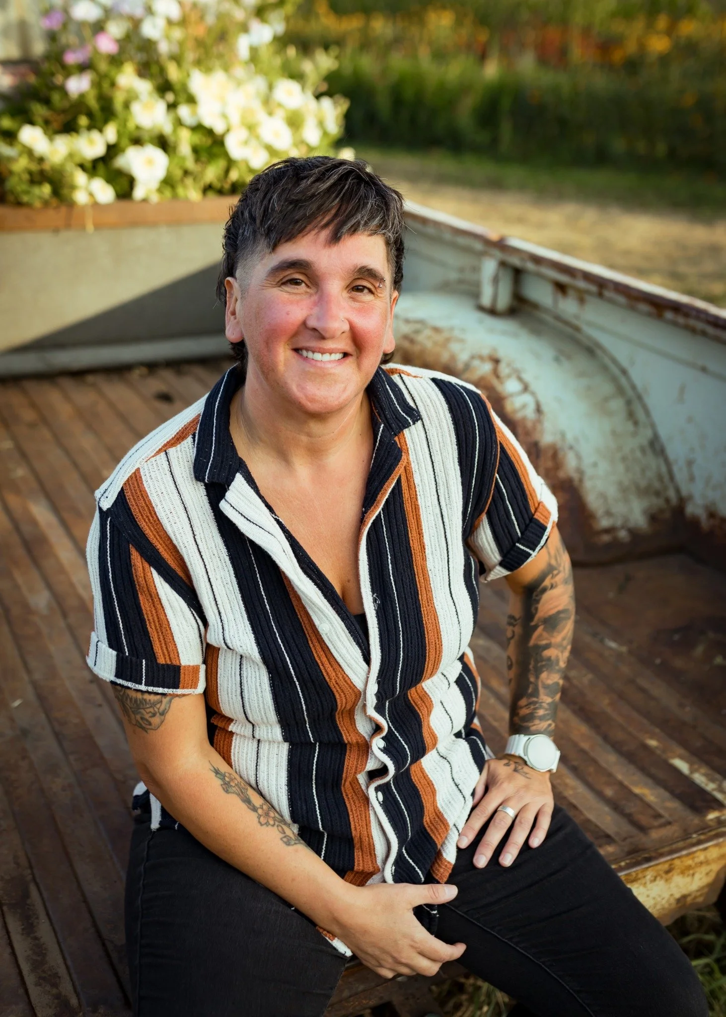 Ali seated outdoors in a striped shirt