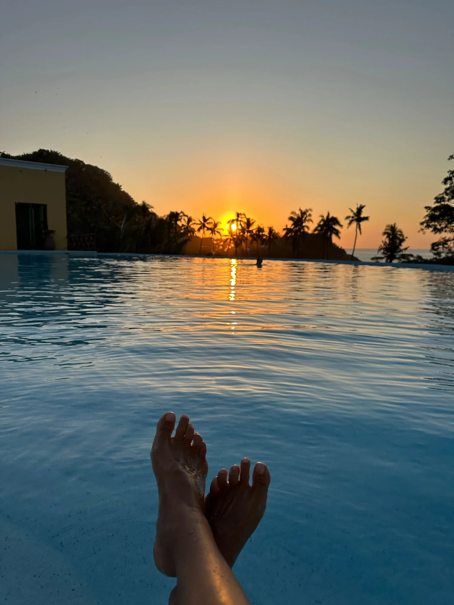 Sunset over an infinity pool and palm trees in Nayarit