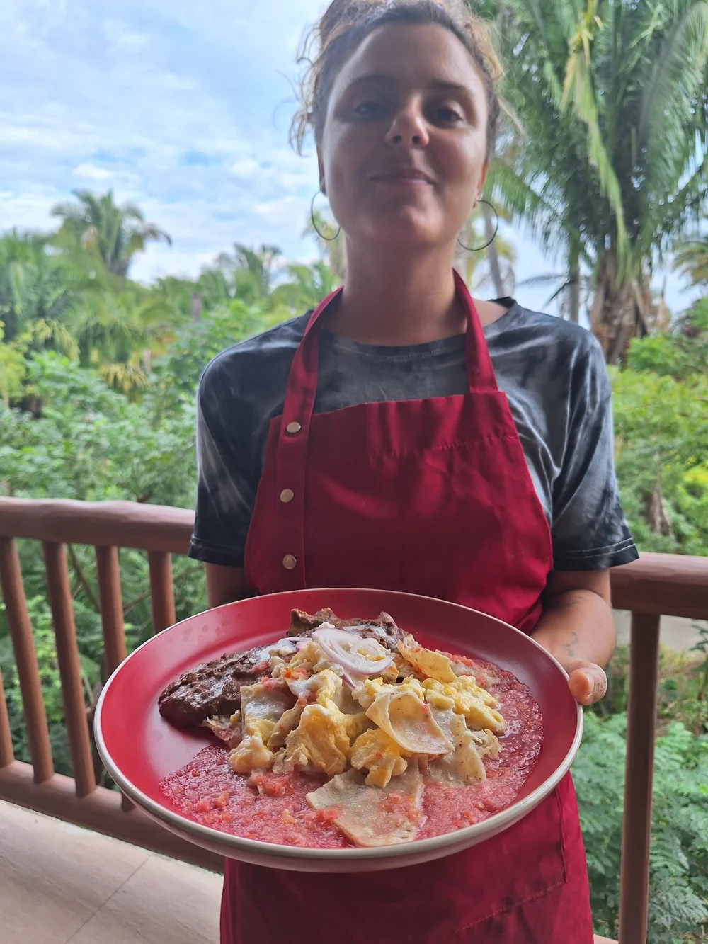 Our chef holding a plate of chilaquiles