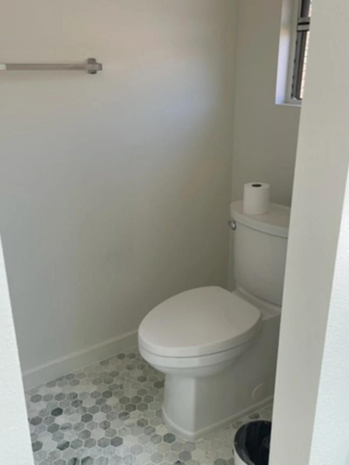 Finished toilet alcove with coordinated patterned tile flooring