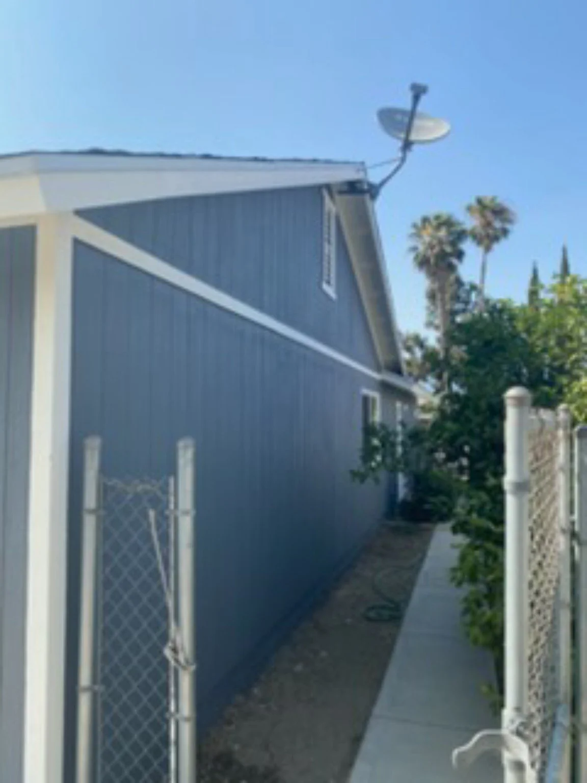 Completed side elevation with gray siding and white window trim