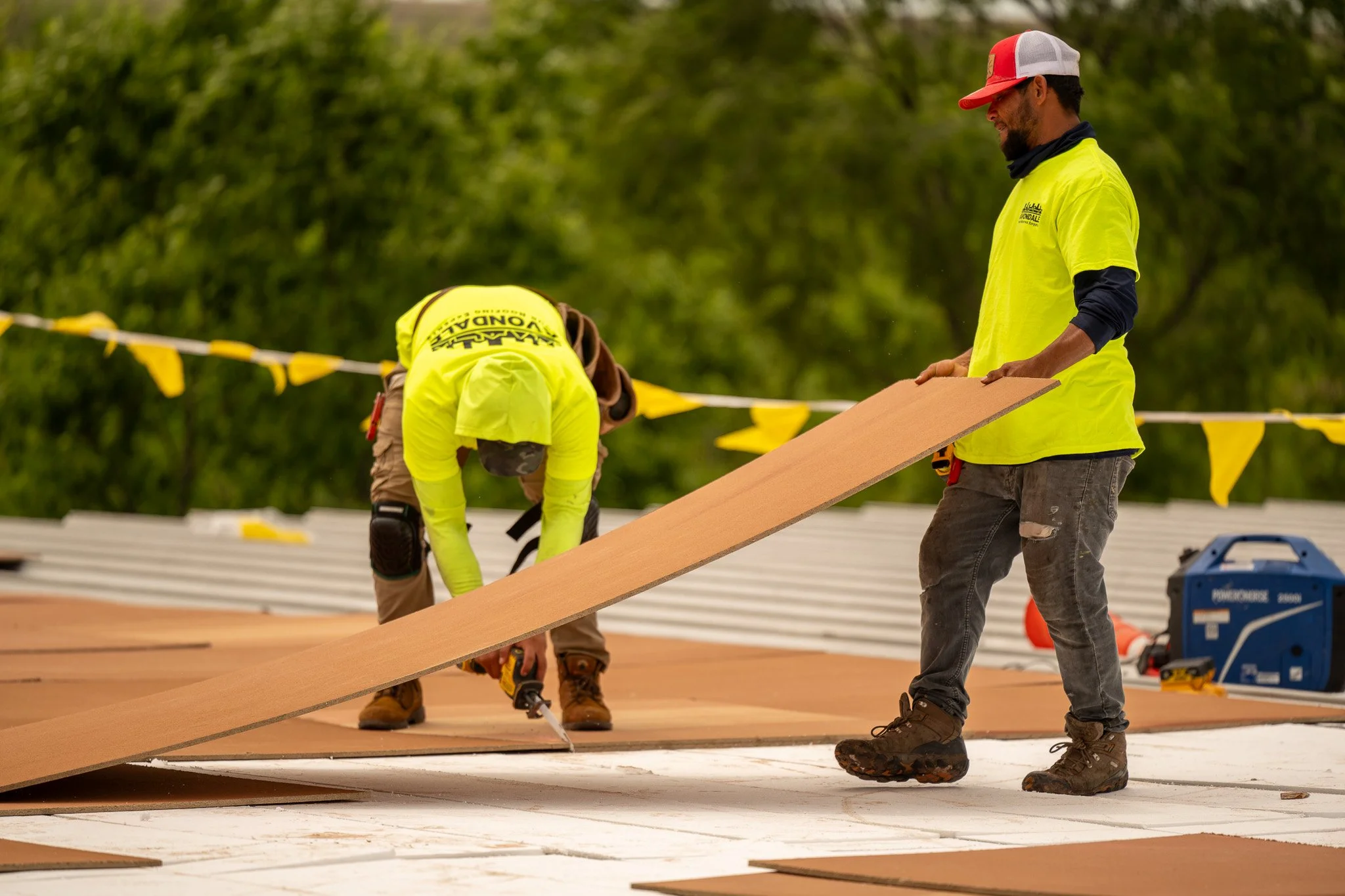 Commercial roofing technician inspecting seam repair on commercial flat roof