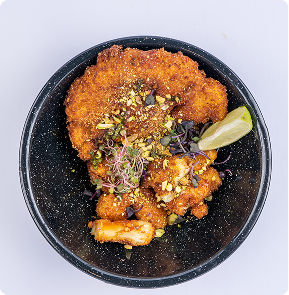 Crispy chicken dish served in a black bowl