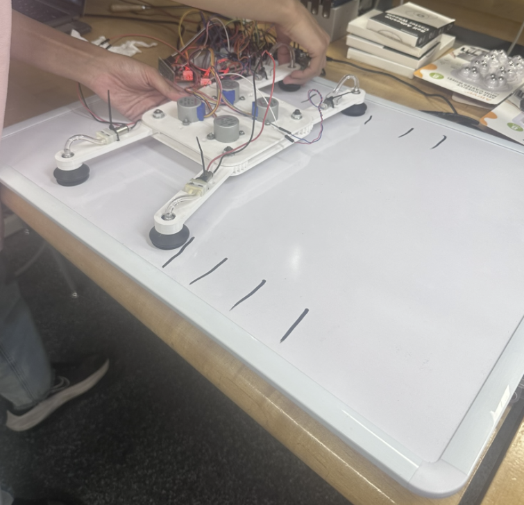 Suction-based quadruped robot prototype on whiteboard test surface