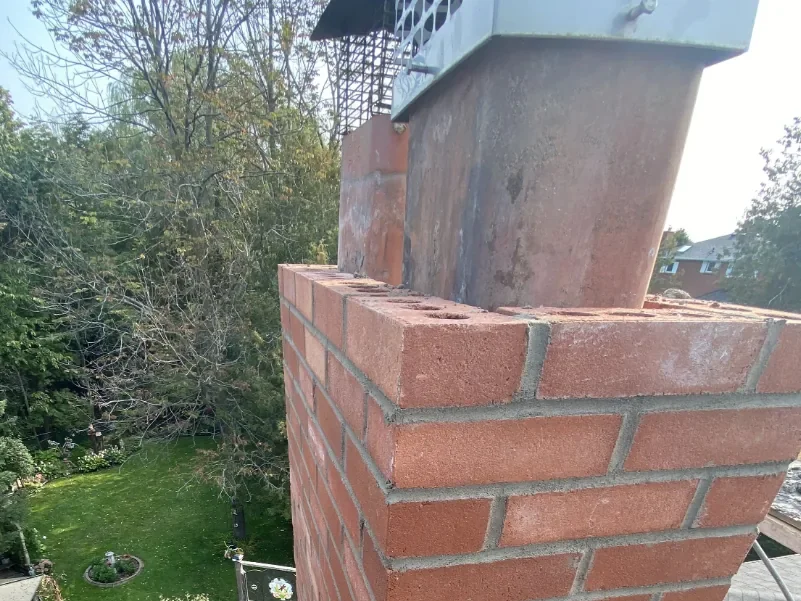 Brick chimney rebuild detail with flue and masonry courses visible.