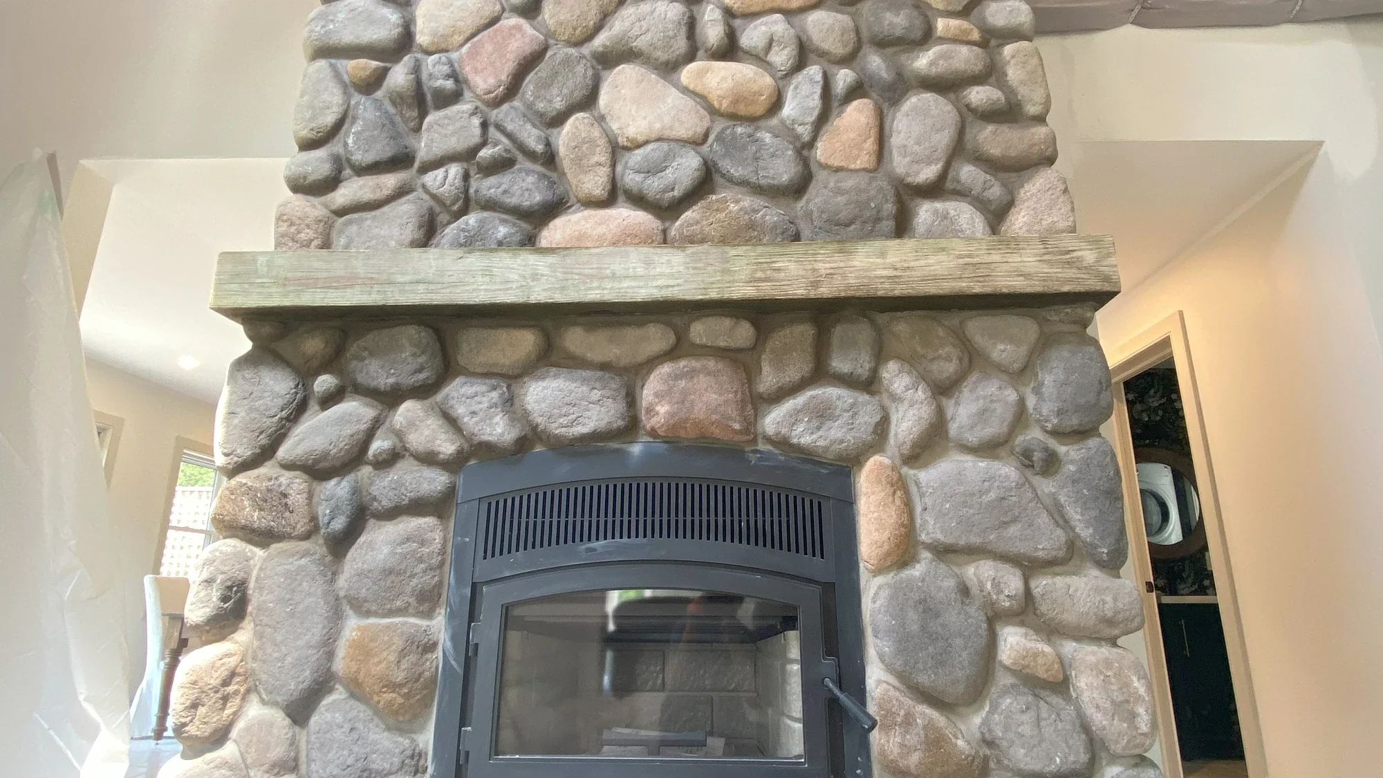 Interior stone fireplace surround with varied stone units and hearth detail.