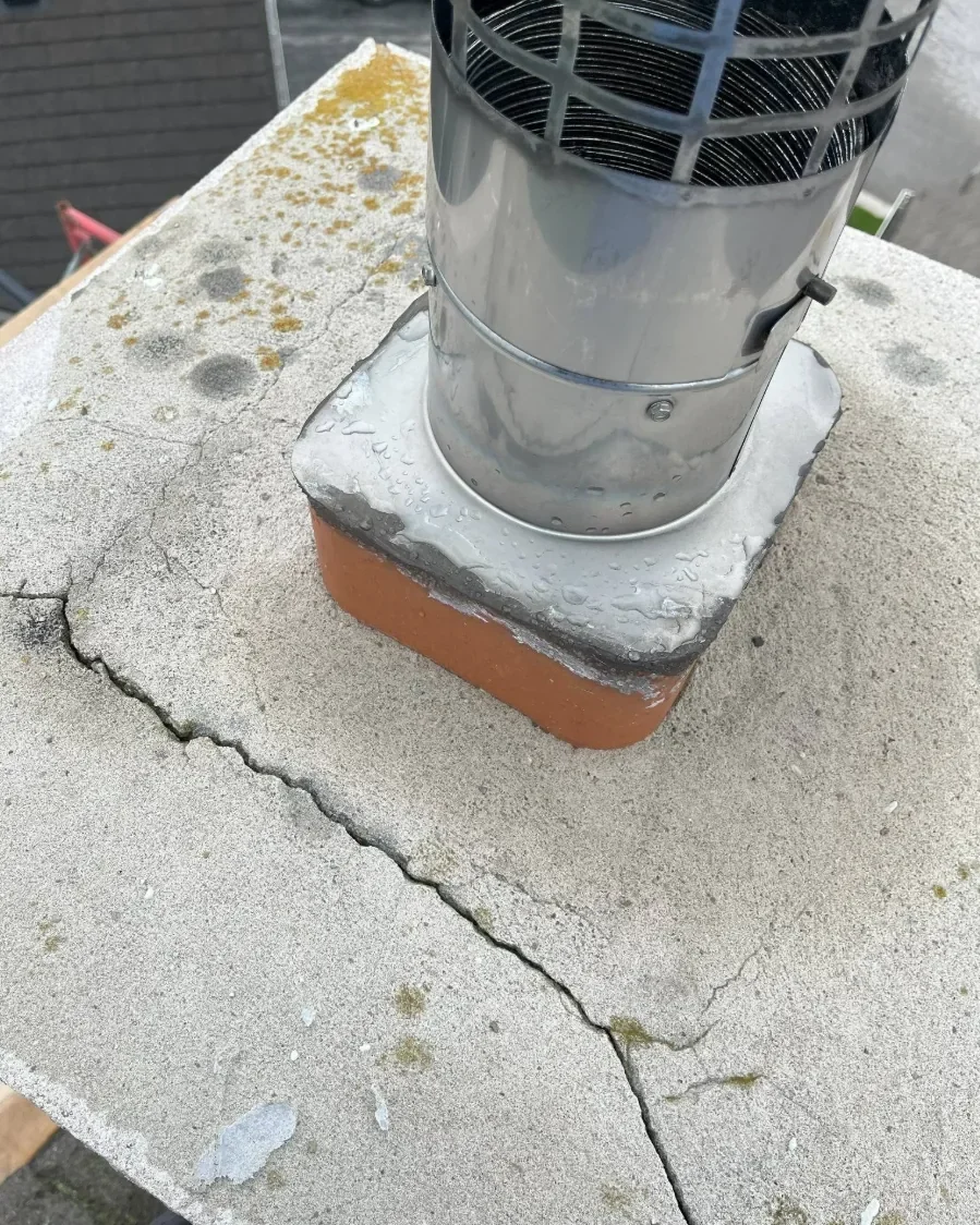 Close view of chimney cap cracking and flue area.