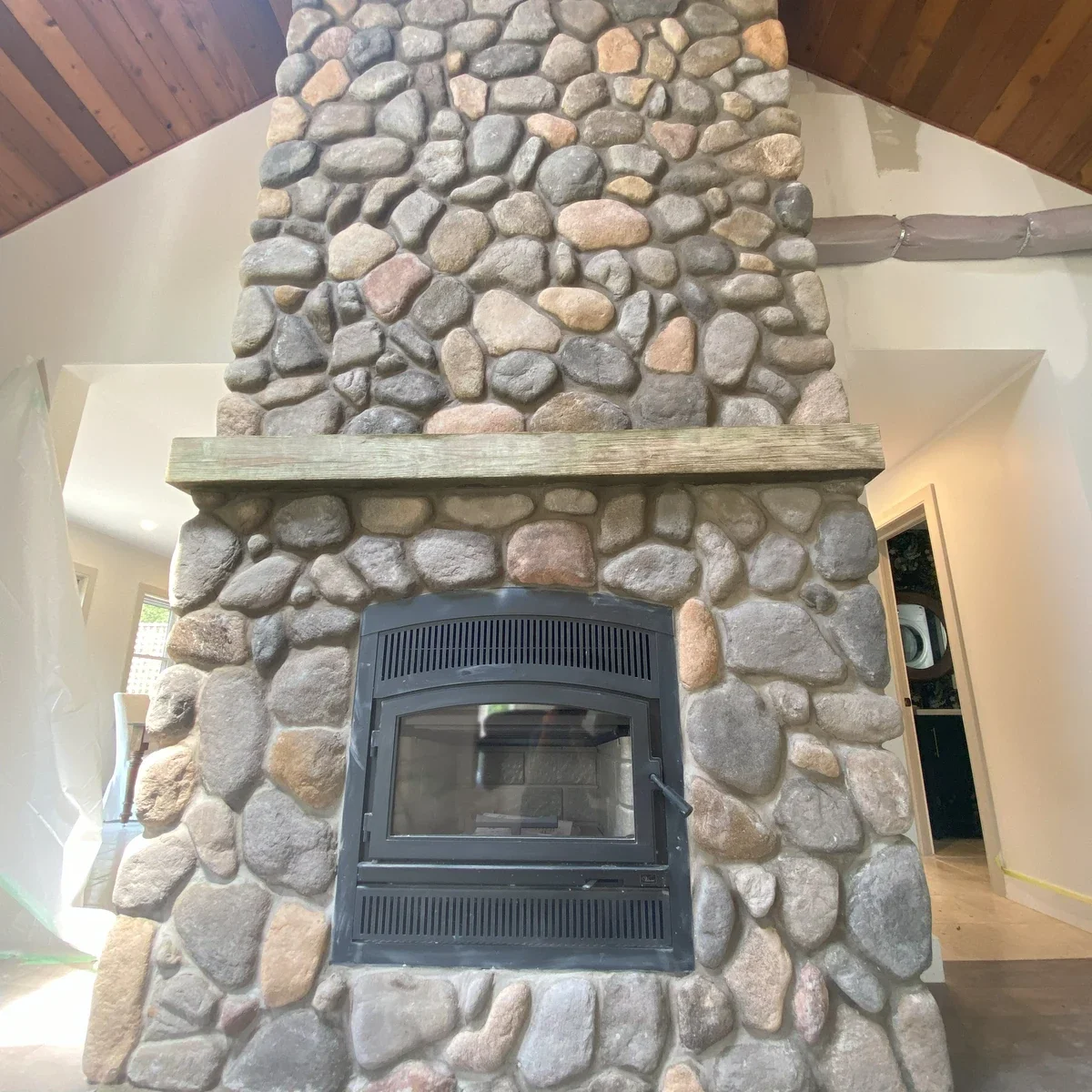 Interior stone fireplace surround with varied stone units and hearth detail