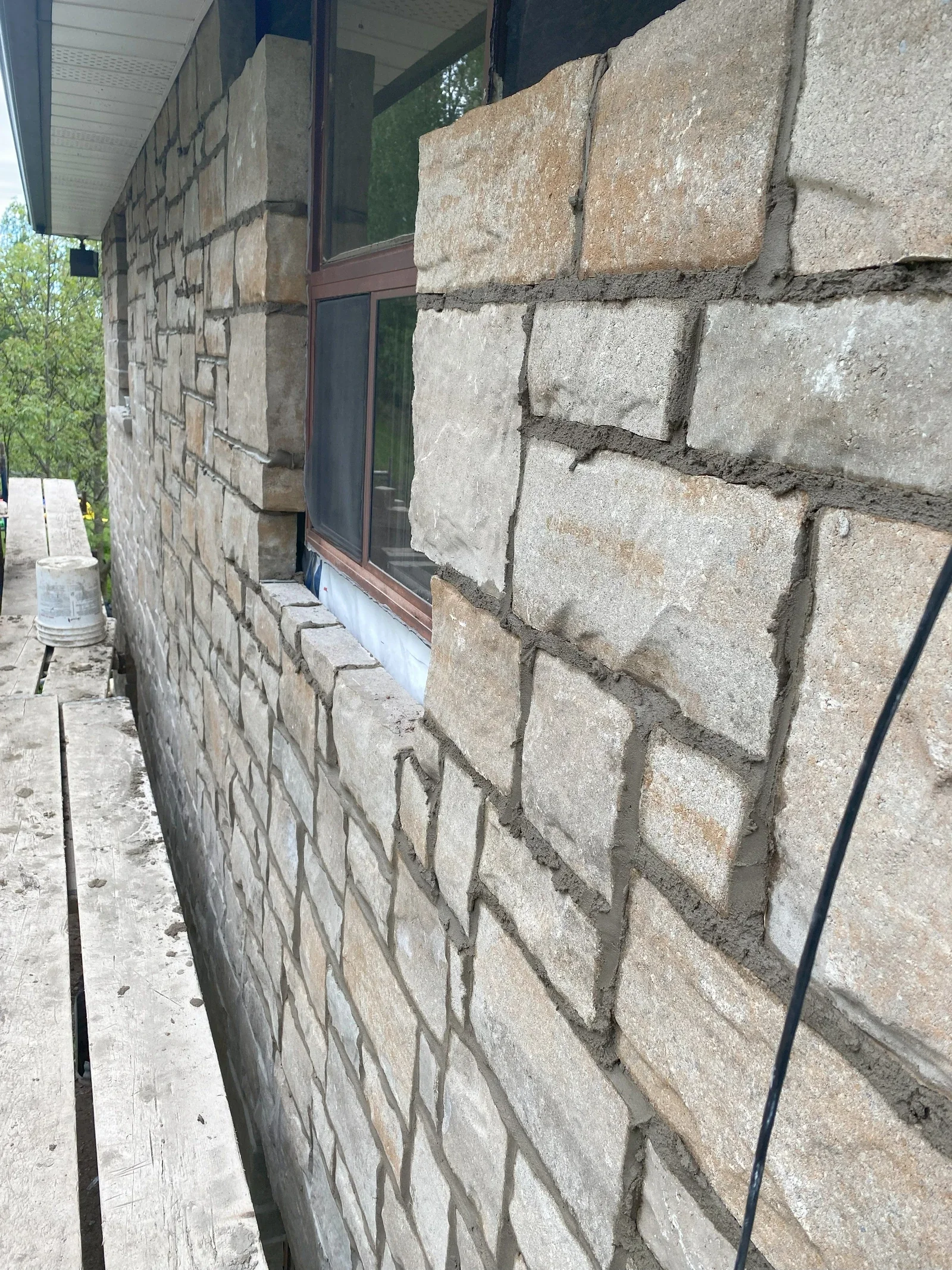 Exterior stone wall detail with window and sill context.