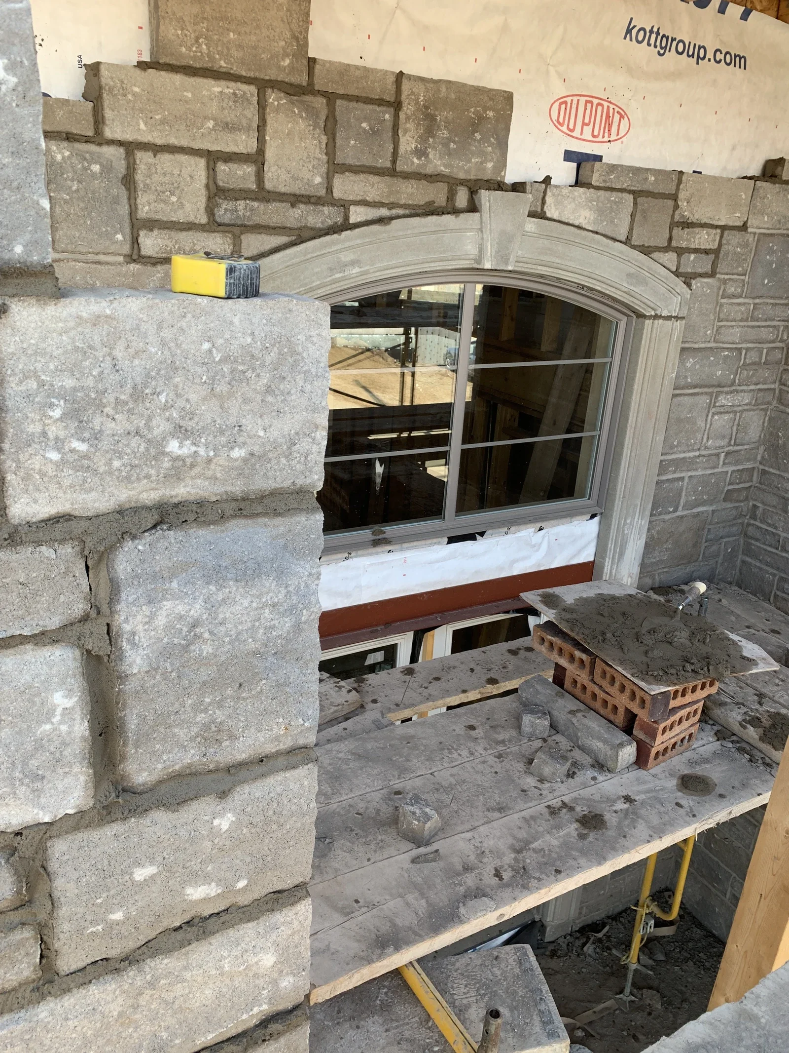 Stone masonry around a window opening during localized repair work.