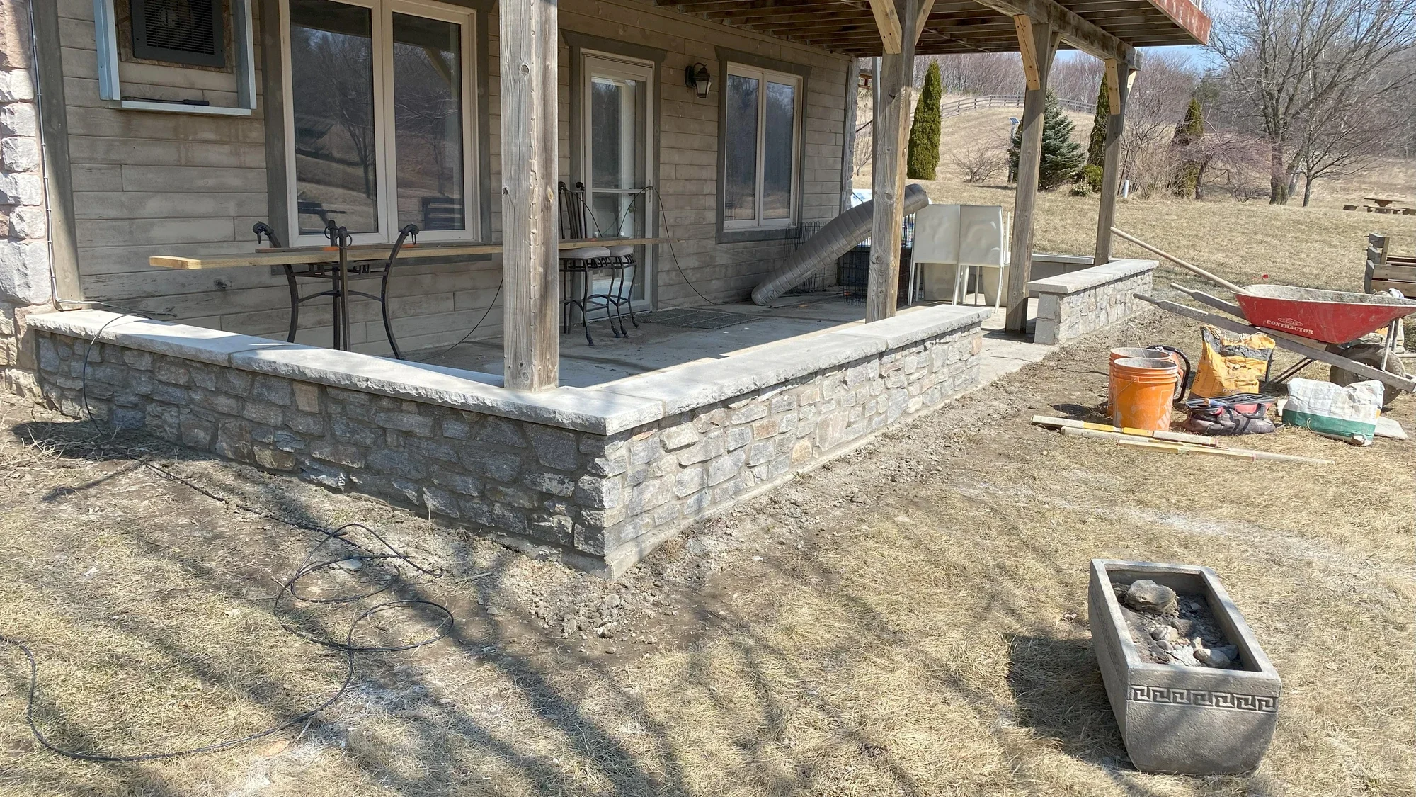 Stone foundation and porch masonry work in residential context.