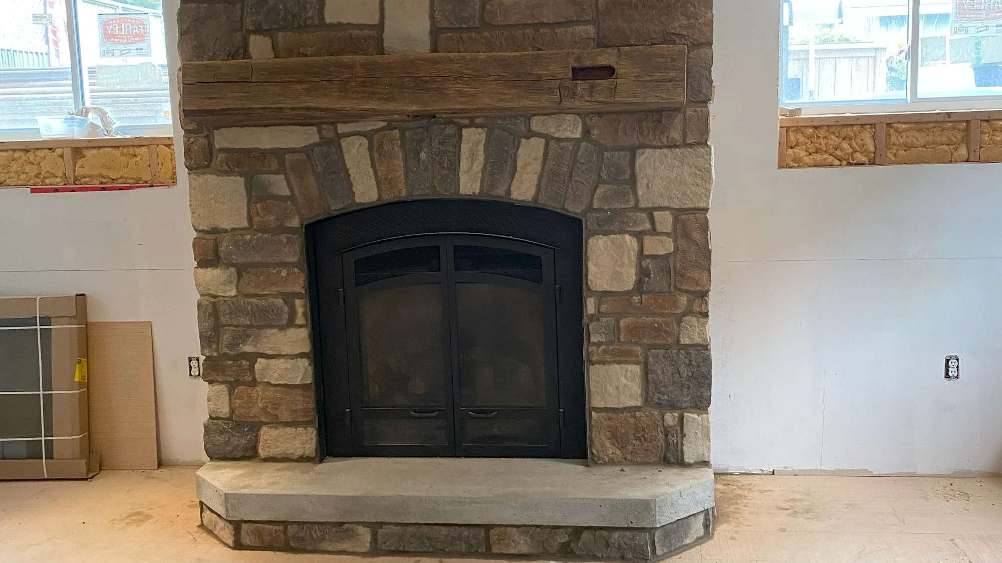 Finished interior stone fireplace wall with hearth detail.