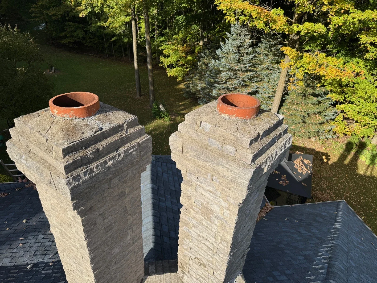 Stone chimney tops with visible masonry courses and roof context.