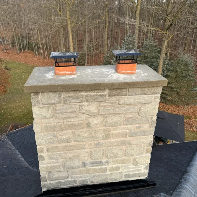 Stone chimney masonry with poured cap and roofline context