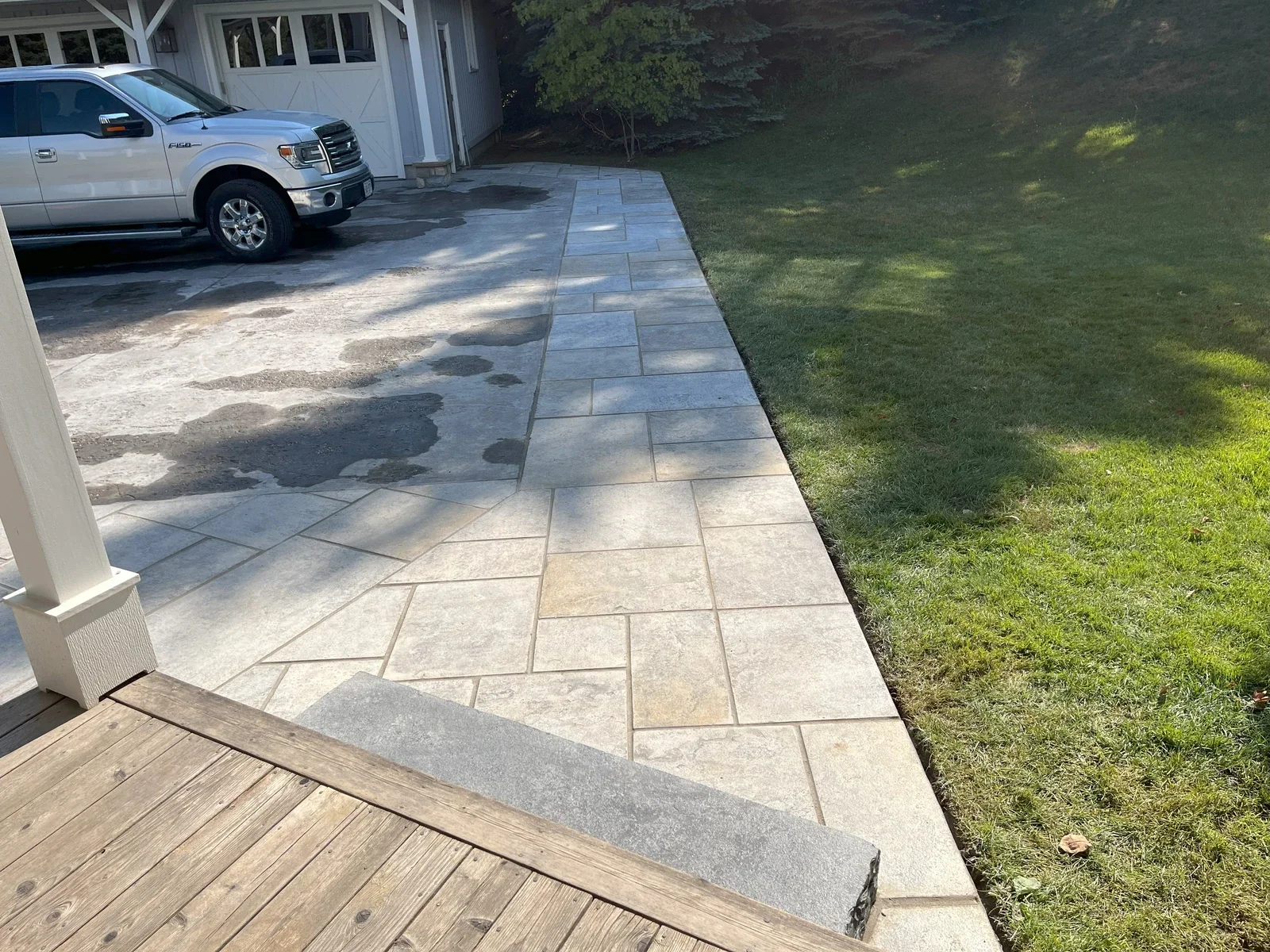 Restored flagstone walkway and driveway-side masonry path.