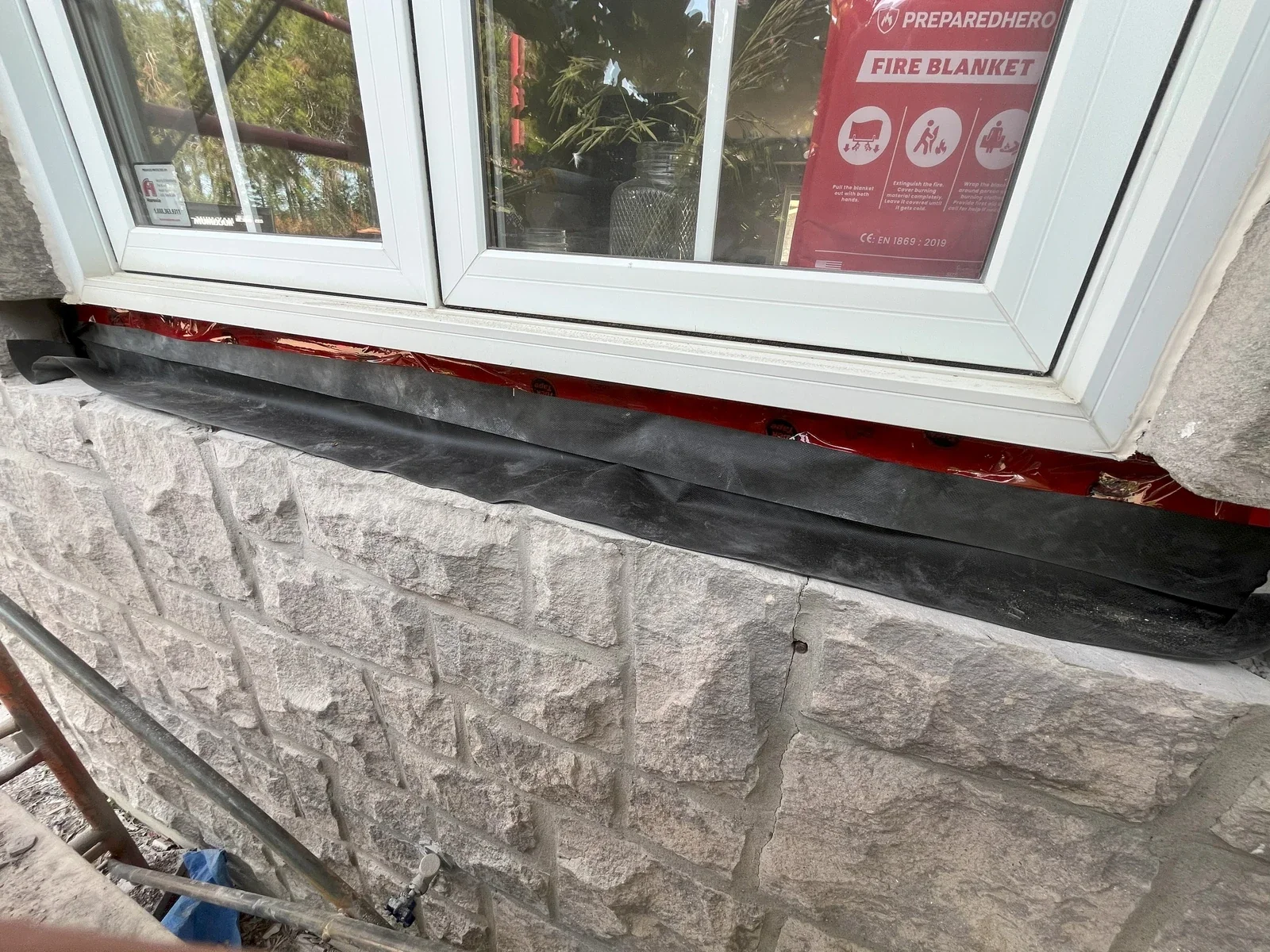 Stone sill installation below a window opening.