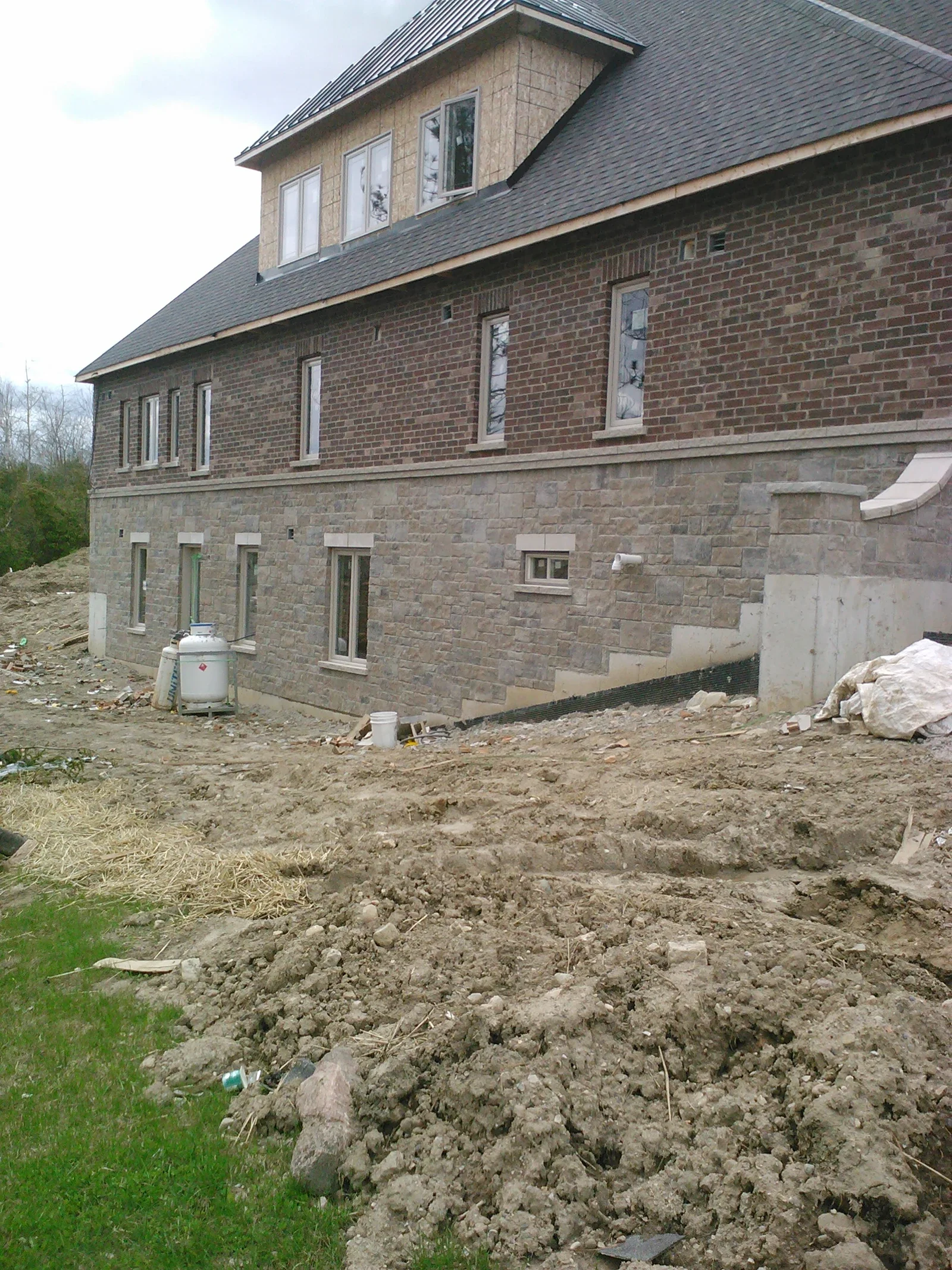 Residential masonry wall with stone and brick exterior context.