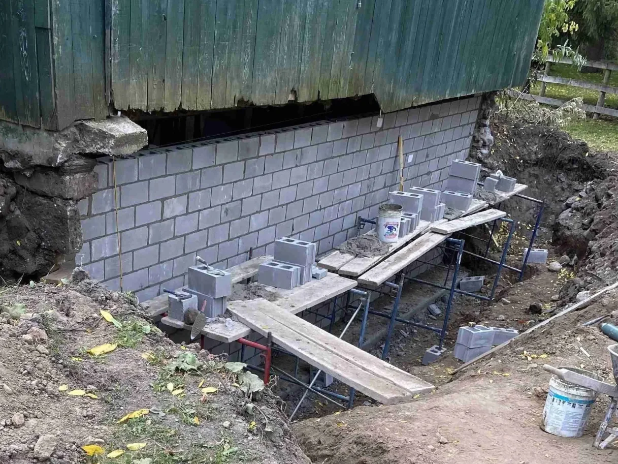Block foundation rebuild work in progress below exterior wall.