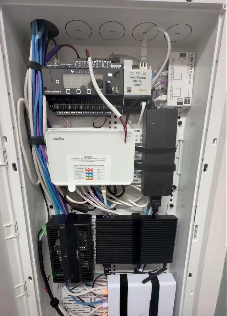 Open structured media enclosure with lighting controller, shade interface, network equipment and neatly routed cabling